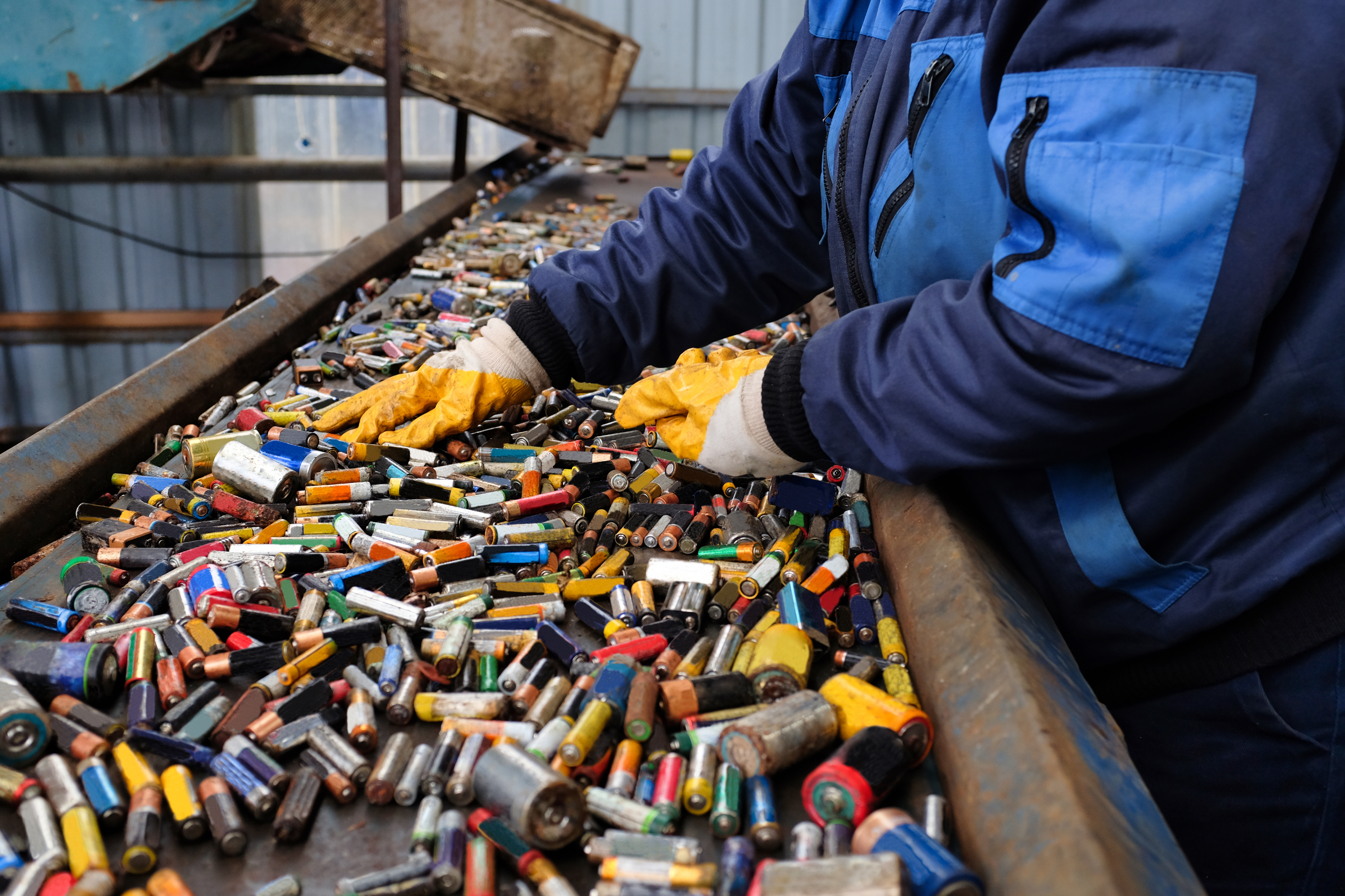 Arbeiter sortiert Batterien auf einem Fließband