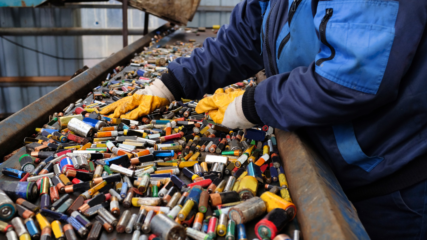 Arbeiter sortiert Batterien auf einem Fließband